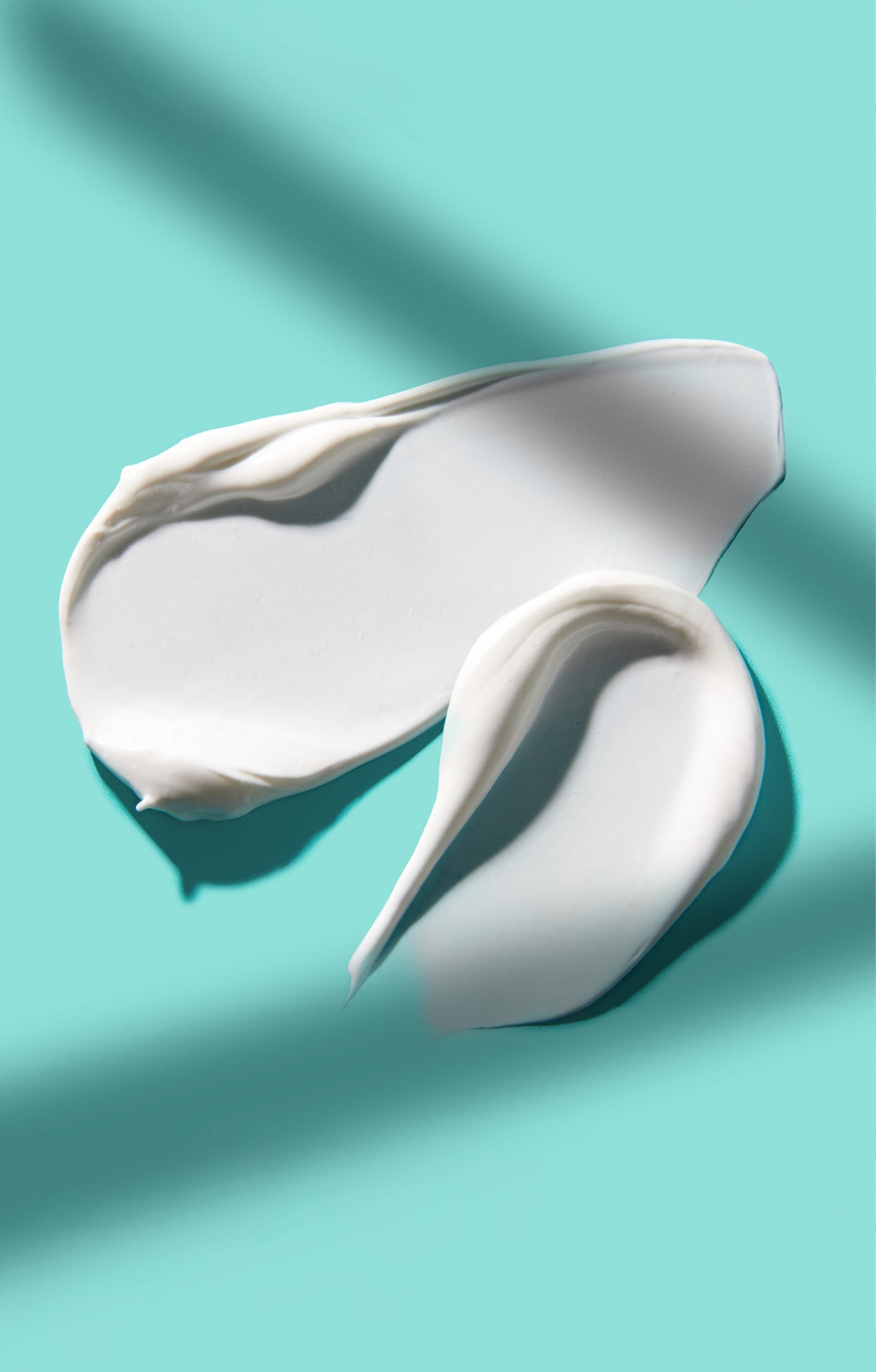 Weightless white cream swatch of Airyday Tough Luxe SPF50 on a teal background